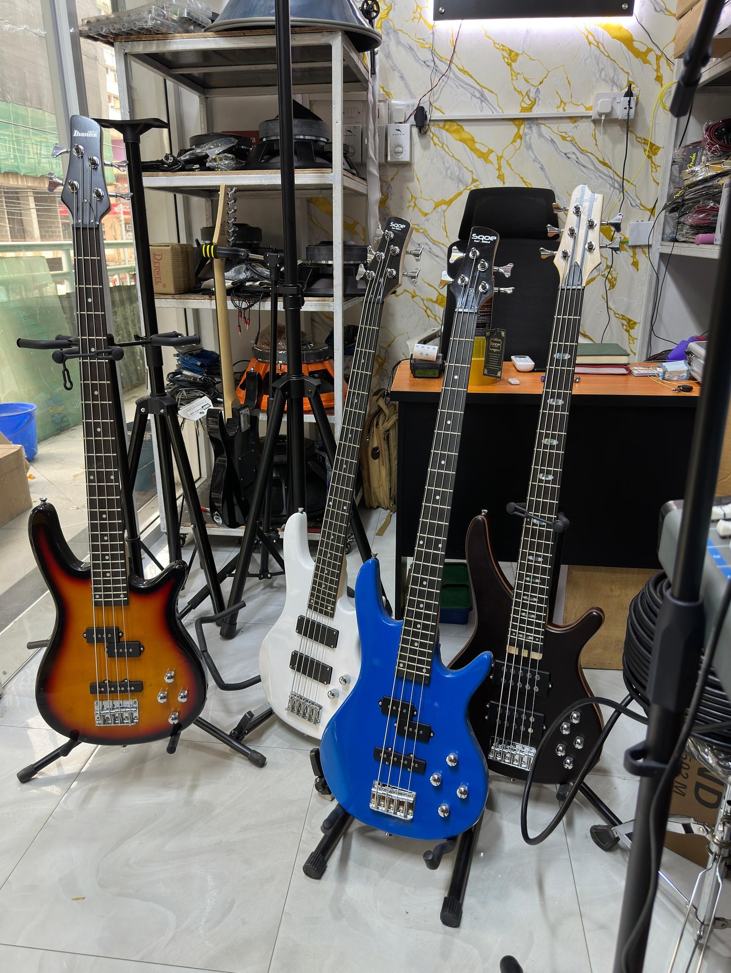 Bass guitars from current Nairobi Sounds stock displayed in the shop